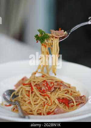 Fourchette Spaghetti avec jambon Spicy dans une assiette blanche, nourriture Banque D'Images