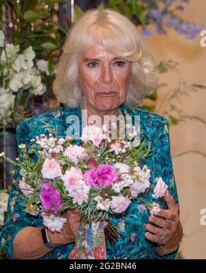 La duchesse de Cornwall tient un bouquet contenant du romarin, un signe de souvenir, reconnaissant qu'aujourd'hui aurait été le 100e anniversaire du duc d'Édimbourg, lorsqu'elle visite l'ouverture d'une exposition de la semaine britannique des fleurs de New Covent Garden Market à Londres. Date de la photo: Jeudi 10 juin 2021. Banque D'Images