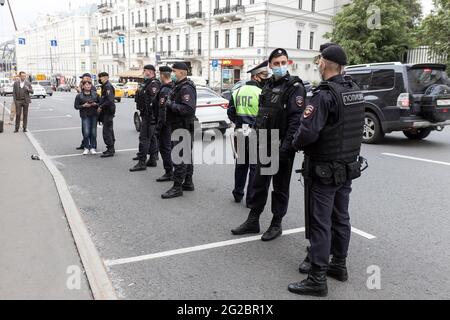 Moscou, Russie - 09 juin 2021, des policiers en uniforme et des masques médicaux sont alignés le long de la route Banque D'Images