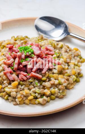 porridge de légumineuses avec bacon frit et ciboulette Banque D'Images