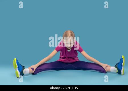 Fille sur le sol faisant l'exercice d'étirement Banque D'Images