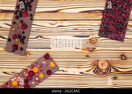 différents types de chocolat avec fruits séchés sur une planche en bois Banque D'Images