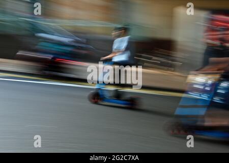 Londres (Royaume-Uni), 10 juin 2021 : deux pilotes de scooter électrique sont vus sur les routes de la région des Docklands à Londres. Banque D'Images