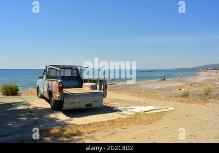 Pick-up rouillé typique garée sur la plage à Kiotari, Rhodes, Grèce Banque D'Images