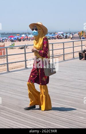 Une femme musulmane légèrement vêtue arrive à la plage de Coney Island, Brooklyn, New York. Banque D'Images