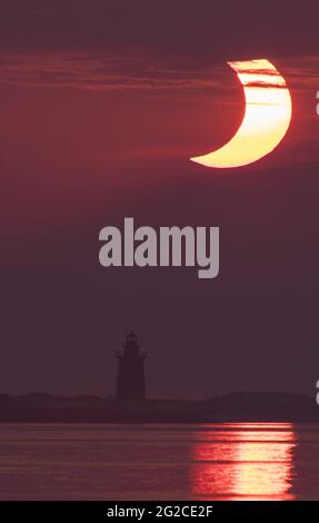 Une éclipse solaire partielle est vue lorsque le soleil se lève derrière le phare de Delaware Breakwater, le jeudi 10 juin 2021, à Lewes Beach, dans le Delaware. L'éclipse solaire annulaire ou âÂ€Âœring de feu n'est visible que dans certaines parties du Groenland, du nord de la Russie et du Canada.photo d'Aubrey Gemignani / NASA via CNP/ABACAPRESS.COM Banque D'Images