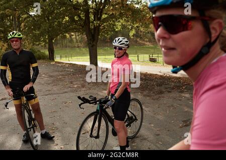 Des cyclistes souriants qui parlent tout en se reposant Banque D'Images