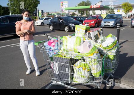 Une bonne cliente qui cherche ses achats hebdomadaires à l'extérieur du supermarché ASDA, parking, Londres, Angleterre, Royaume-Uni, temps ensoleillé, ciel bleu Banque D'Images