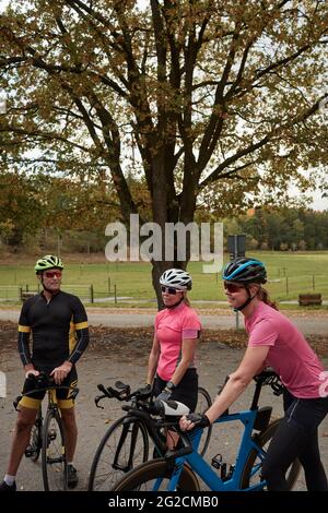 Des cyclistes souriants qui parlent tout en se reposant Banque D'Images