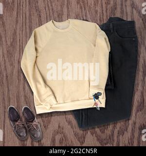 Chandail jaune vêtements Mockup en jaune chiné avec jeans noirs, chaussures brunes et clés sur un fond de bois. Décontracté vêtements chemise maquette Banque D'Images