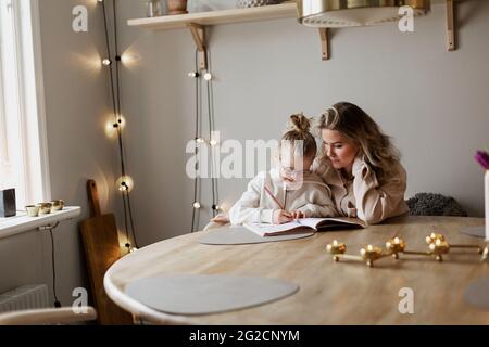 Mère fille aidant à faire leurs devoirs Banque D'Images