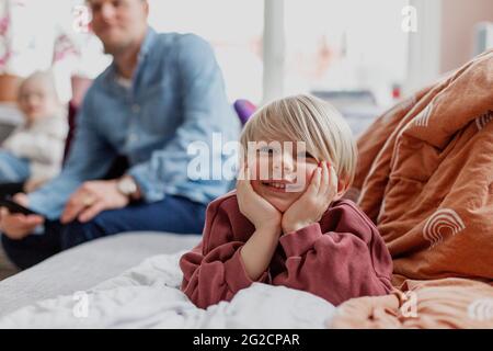 Smiling boy lying on bed Banque D'Images