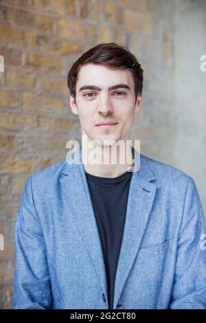 Portrait de jeune homme contre le mur de brique Banque D'Images