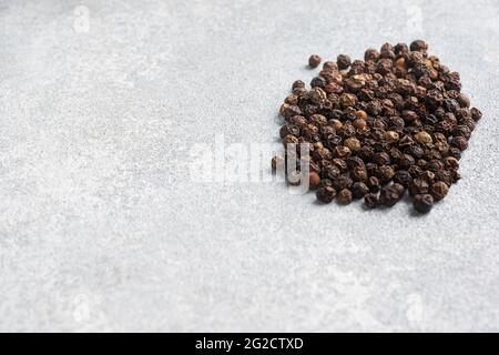 Petits pois au poivre noir sur fond de béton gris, espace de copie Banque D'Images