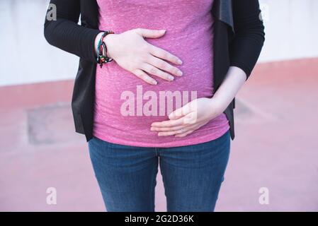 Gros plan d'une femme touchant son ventre enceinte avec ses mains Banque D'Images