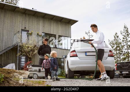 Famille avec tout-petits devant la maison Banque D'Images