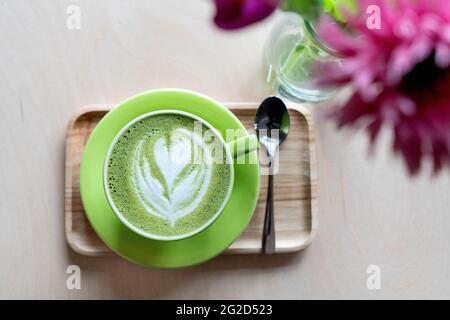 Matcha latte avec un coeur dans une tasse verte dans un café Banque D'Images