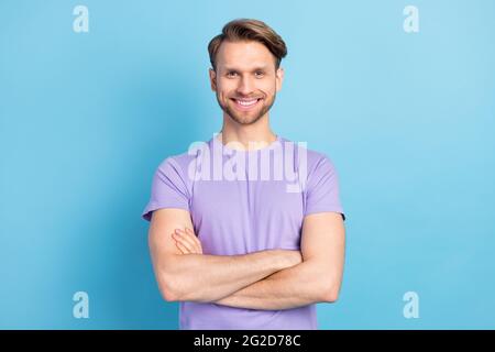 Photo portrait d'un jeune homme aux mains pliées souriant isolé sur fond bleu pastel Banque D'Images