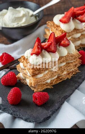 Fraises, framboises et crème mille feuille sur assiette en pierre noire Banque D'Images