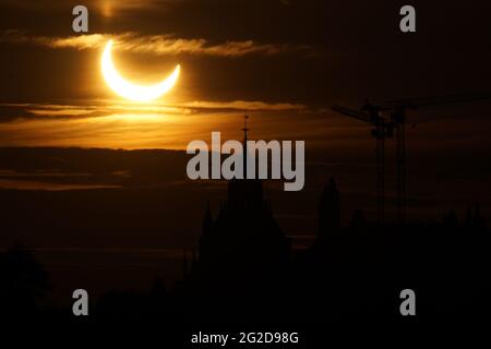 Ottawa, Canada. Le 10 juin 2021 : une éclipse solaire partielle est vue sur la colline du Parlement à Ottawa, Canada - le jeudi 10 juin 2021. L'éclipse solaire annulaire ou « anneau de feu » n'est visible que par certaines personnes au Groenland, dans le nord de la Russie et au Canada. Ici, le soleil est vu juste après le point éclipse maximum à seulement trois degrés au-dessus de l'horizon, au-dessus des bâtiments du Parlement. Credit: George Ross/Alay Live News Banque D'Images