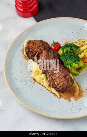 Filet de bœuf grillé sur une assiette en céramique avec beurre et thym. Recette de filet mignon avec légumes Banque D'Images