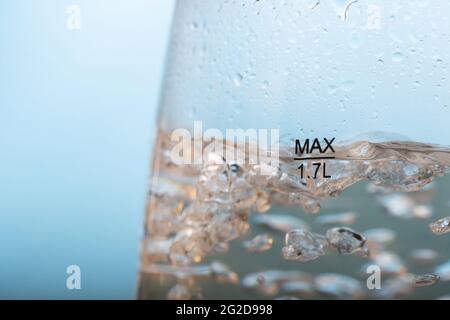 Une eau est bouillie dans une bouilloire électrique avec des murs transparents, gros plan. Banque D'Images