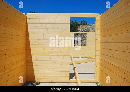 Cadre de porte dans une maison en bloc construite en pièce, une maison en bois prédécoupée assemblée sur place. Certaines poutres de toit et un tournevis électrique sont sur le plancher Banque D'Images