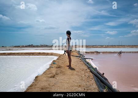 Manaure, la Guajira, Colombie - Mai 29 2021: Jeune femme debout au milieu des fosses Pink et Blue Sky Waters dans la plus importante maritime sa Banque D'Images