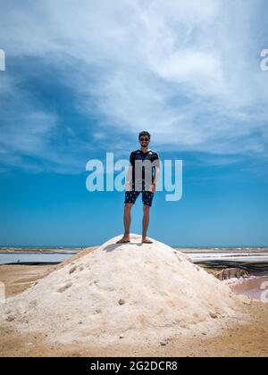 Manaure, la Guajira, Colombie - Mai 29 2021: Jeune homme latin debout dans une montagne de sel dans les plus importantes salines maritimes du pays Banque D'Images