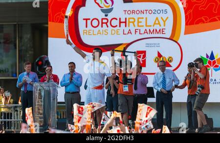 Le Toronto Raptor Greivis Vazquez a porté le flambeau sur scène pendant la célébration du relais du flambeau Pan Am au Nathan Phillips Square à Toronto un jour b Banque D'Images