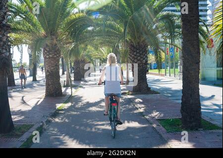 Une femme fait du vélo pour visiter les pistes cyclables et les infrastructures cyclables de Barcelone. Banque D'Images