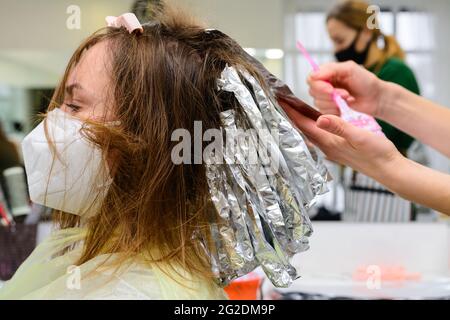 Le travail des coiffeurs pendant la quarantaine mondiale, le processus d'application de colorant capillaire. Nouveau Banque D'Images