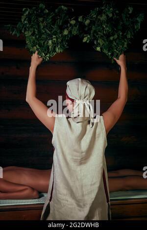 utilisation des balais de bain dans un sauna à vapeur traditionnel banya Banque D'Images