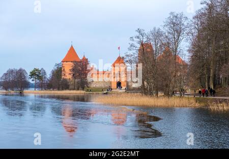 Trakai, Lituanie - 16 février 2020 : paysage du château de l'île Trakai, lac et pont en bois au coucher du soleil, comté de Vilnius, Lituanie. Banque D'Images