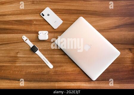 Biélorussie, région de Minsk - 17 mars 2020 : ensemble de gadgets de pomme : ordinateur portable, iphone, montre de pomme et aéropodes sur fond de table en bois. Banque D'Images