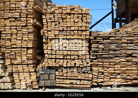 Beaucoup de planches dans l'entrepôt. Les barres de bois sont empilées. Matériaux de construction. Produits de l'industrie de la transformation du bois. Banque D'Images