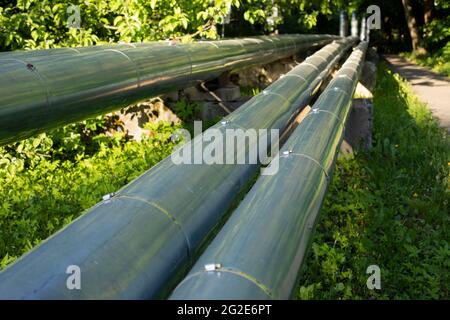 Tuyaux de chauffage à l'extérieur. Okcommunications dans la ville. L'eau chaude s'écoule dans les tuyaux. Tuyaux revêtus d'acier inoxydable. Banque D'Images