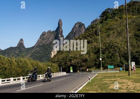 Trafic passant à l'échangeur à feuilles cloverlevers de l'autoroute Rio-Teresopolis avec notre doigt de Dame, le doigt de Dieu et les pics de Cabeca de Peixe à l'arrière. Banque D'Images