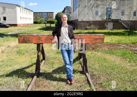 Pasewalk, Allemagne. 10 juin 2021. L'acteur Martin Brambach, en tant que Ronnie, est sur le point de filmer le film « McLenBurger - Once in a Lifetime » sur le terrain d'une ancienne ferme GDR. Dans le cadre de la comédie ARD Degeto, le plus jeune gérant de la cantine de GDR Times ouvre un restaurant avec des hamburgers faits maison et d'autres spécialités régionales. Elle est confrontée à la concurrence d'une chaîne de hamburgers dans la région. Le tournage a lieu en Mecklembourg-Poméranie occidentale et à Berlin. Credit: Jens Kalaene/dpa-Zentralbild/dpa/Alay Live News Banque D'Images