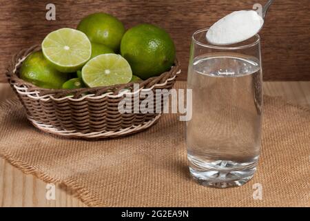 Eau, bicarbonate de soude et citron; photo sur fond de bois. Banque D'Images