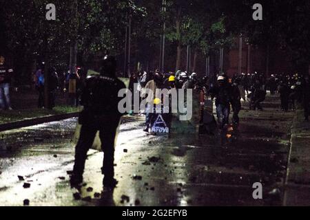 Des affrontements et des troubles entre manifestants utilisant des bombes molotov, des rochers et des lasers avec la police anti-émeute de Colombie alors que des mounds ont inondé les rues de medellin dans une protestation anti-gouvernementale contre le président Ivan Duque, brutalité et inégalités de la police, le 9 juin 2021, à Medellin, en Colombie Banque D'Images