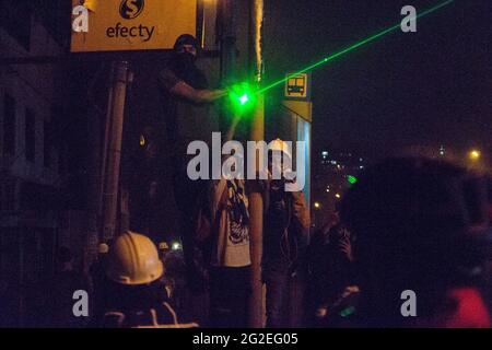 Des affrontements et des troubles entre manifestants utilisant des bombes molotov, des rochers et des lasers avec la police anti-émeute de Colombie alors que des mounds ont inondé les rues de medellin dans une protestation anti-gouvernementale contre le président Ivan Duque, brutalité et inégalités de la police, le 9 juin 2021, à Medellin, en Colombie Banque D'Images