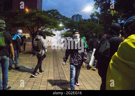 Des affrontements et des troubles entre manifestants utilisant des bombes molotov, des rochers et des lasers avec la police anti-émeute de Colombie alors que des mounds ont inondé les rues de medellin dans une protestation anti-gouvernementale contre le président Ivan Duque, brutalité et inégalités de la police, le 9 juin 2021, à Medellin, en Colombie Banque D'Images