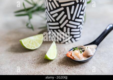 Soupe asiatique traditionnelle Tom yum kung dans une tasse de papier artisanal jetable. Soupe à emporter, livraison de nourriture. Emporter la nourriture. Gros plan. Banque D'Images