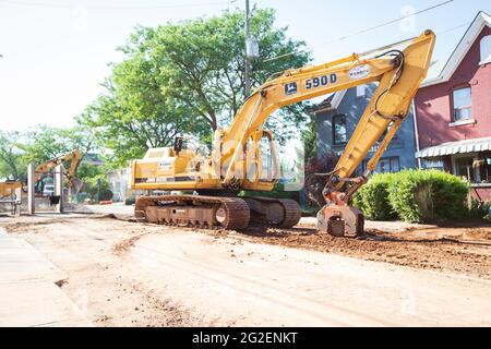 Des machines de construction à usage intensif travaillent sur la route pour le remplacement des tuyaux d'égout dans le centre-ville de Hamilton. Banque D'Images