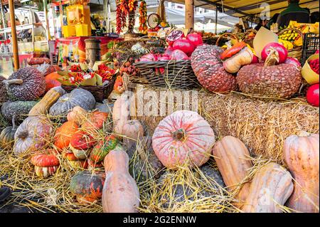 Une exposition colorée de fruits et de variétés végétales disposés sur des haystacks sur un marché. Banque D'Images