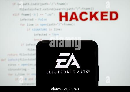 EA Electronic arts logo vu sur une silhouette de smartphone et simple code source sur avec le mot PIRATÉ sur fond flou. Concept. PHOTO RÉELLE, Banque D'Images