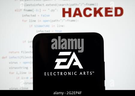 EA Electronic arts logo vu sur une silhouette de smartphone et simple code source sur avec le mot PIRATÉ sur fond flou. Concept. PHOTO RÉELLE, Banque D'Images