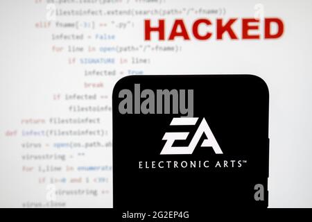 EA Electronic arts logo vu sur une silhouette de smartphone et simple code source sur avec le mot PIRATÉ sur fond flou. Concept. PHOTO RÉELLE, Banque D'Images