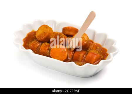 German Currywurst, saucisse en tranches assaisonnée de sauce tomate chaude et de poudre de curry, isolé Banque D'Images